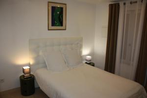 ein Schlafzimmer mit einem großen weißen Bett mit zwei Lampen in der Unterkunft Le Clos Saint Nizier in Troyes