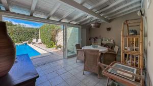 a dining room with a table and a swimming pool at Très beau mas provençal proche Alpilles in Barbentane