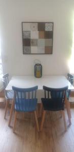 einem Esstisch mit zwei blauen Stühlen in der Unterkunft Studio spacieux et lumineux proche DisneylandParis in Sammeron