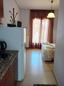 a kitchen with a white refrigerator and a bed at studio nufaro in Mytilene