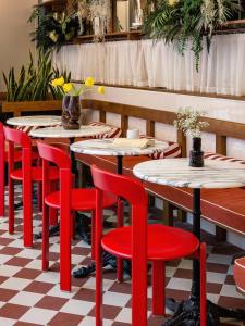 uma fila de mesas e cadeiras vermelhas num restaurante em Hôtel Dalila em Paris