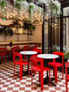 a restaurant with red tables and red chairs at Hotel le 18 Paris in Paris