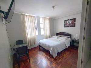 una camera con un letto e una televisione di hospedaje encantada a Cajamarca