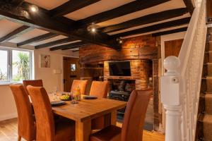 - une salle à manger avec une table et des chaises en bois dans l'établissement Pass the Keys Charming Cottage Stunning Views, à Cheswardine
