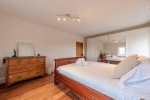 - une chambre avec un lit, une commode et un miroir dans l'établissement Pass the Keys Charming Cottage Stunning Views, à Cheswardine