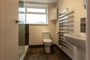 a bathroom with a toilet and a sink and a window at Pass the Keys Charming Cottage Stunning Views in Cheswardine +29 photos
