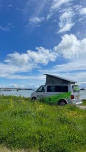 a van with its roof up parked next to the water at Campervan Ireland Rentals in Dardistown