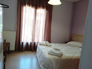 a bedroom with a bed and a large window at studio nufaro in Mytilene