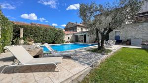 a swimming pool in a yard with a white lounge chair at Très beau mas provençal proche Alpilles in Barbentane