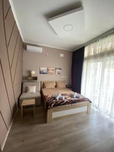 una camera con letto, divano e finestra di Migato Apartments a Gevgelija