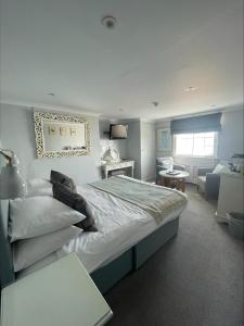 a bedroom with a large bed and a living room at The Royal Albion in Broadstairs