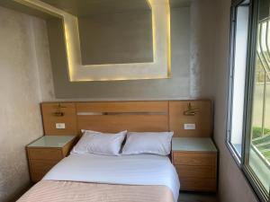 1 dormitorio con cama, espejo y ventana en La location de la mer, en Dar Bouazza