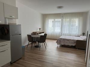 Monolocale Pordenone centro في بوردينوني: مطبخ وغرفة معيشة مع طاولة وكراسي
