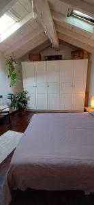 um quarto com uma cama grande e armários brancos em La casetta nel verde em Ronago