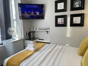 ロンドンにあるTrinity House Hotelのベッドルーム1室(ベッド1台、壁掛けテレビ付)