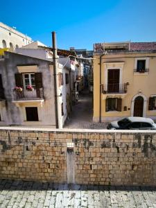 Una calle de la ciudad con edificios y una pared de ladrillos en da Nonna Maria, en Scicli