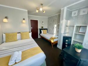 ein Hotelzimmer mit 2 Betten und einem Kamin in der Unterkunft Trinity House Hotel in London