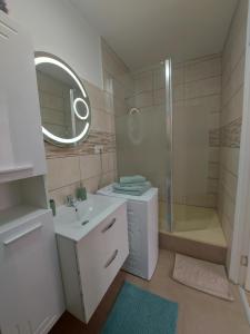 a white bathroom with a sink and a shower at Darris Apartament Ultracentral in Oradea