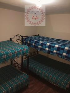 a room with two bunk beds and a sign on the wall at La casita de Lulú in Arequipa