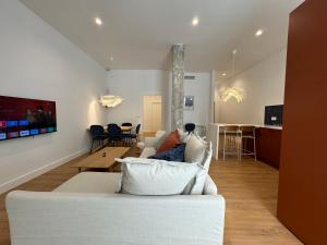 sala de estar con sofá blanco y cocina en Arroyo 3 Apartments, en Sevilla