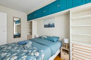 1 dormitorio con 1 cama y armarios azules en Lovely flat in Paris en París