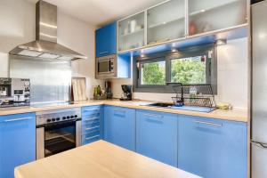 a blue kitchen with blue cabinets and a window at Marinada in Benidorm
