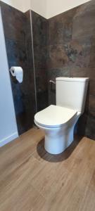 a white toilet in a bathroom with a wooden floor at CASAPIETRA in Brando +6 photos