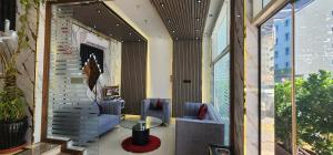 a lobby with two chairs and a table and windows at Al Smou Hotel Apartments - MAHA HOSPITALITY GROUP in Ajman 