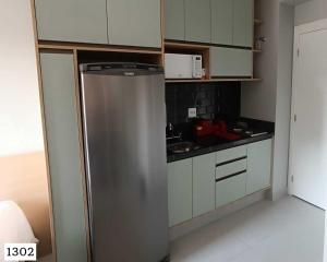 a stainless steel refrigerator in a small kitchen at BookSampa Be Urban próximo ao Metro Brooklin in Sao Paulo