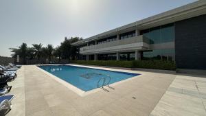 a swimming pool in front of a building at EasyGo - Polo Residence C5 1 Bedroom in Dubai