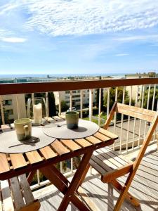 Una mesa en un balcón con vista al mar. en Joli 2 pièces - Proche aéroport - Terrasse vue mer, en Niza