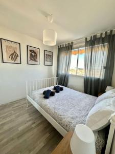 Un dormitorio con una cama con almohadas azules. en Joli 2 pièces - Proche aéroport - Terrasse vue mer, en Niza