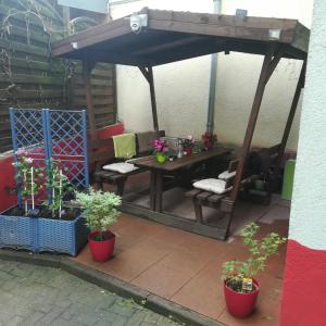 een patio met een tafel en stoelen onder een blauwe parasol bij Bei Charlotte in Sonneberg