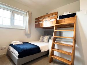 a bedroom with a bunk bed and a ladder at Hebaska~Watergate Bay~3 Bedroom in Porth