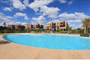 a large swimming pool in a resort with apartments at Appart-Oasis Piscine et Terrasses in Marrakesh