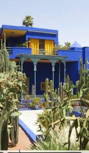 a blue house with cacti in front of it at Appart-Oasis Piscine et Terrasses in Marrakesh