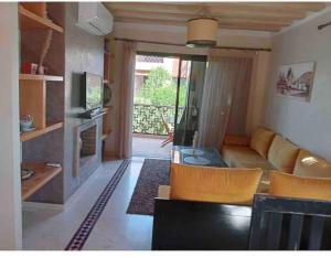 a living room with a couch and a television at Appart-Oasis Piscine et Terrasses in Marrakesh