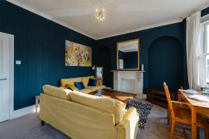 ein Wohnzimmer mit einem Sofa und einem Esstisch in der Unterkunft 4 bedroom Stunning Flat Near Westfield & Trains in London