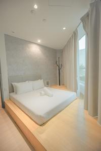 ein weißes Bett in einem Zimmer mit einem großen Fenster in der Unterkunft Double H Boutique Hotel in Kuala Terengganu