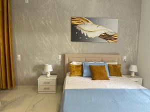 a bedroom with a bed with blue and gold pillows at Katerina's Relaxing Apartment in Sarandë