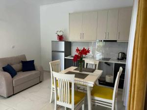 a kitchen with a table with a vase of flowers on it at Katerina's Relaxing Apartment in Sarandë