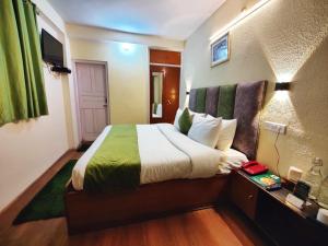 una habitación de hotel con una cama grande en una habitación en Jakhu Vibes, en Shimla