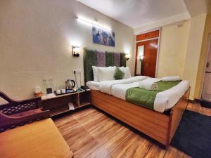 1 dormitorio con 1 cama grande y suelo de madera en Jakhu Vibes, en Shimla