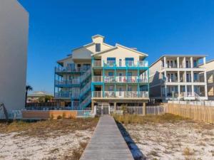 a large building on the beach with a boardwalk at Beautiful 3 Bedroom BEACHFRONT Condo (F3) - Sleeps 10 in Gulf Shores