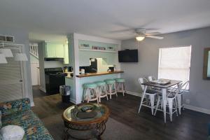 a living room with a couch and a table and a kitchen at Direct Gulf Views with Deeded Beach Access (#17) - Sleeps 7 in Gulf Shores