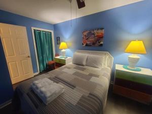 een slaapkamer met een bed met blauwe muren en 2 lampen bij Beautiful 3 Bedroom BEACHFRONT Condo (F3) - Sleeps 10 in Gulf Shores