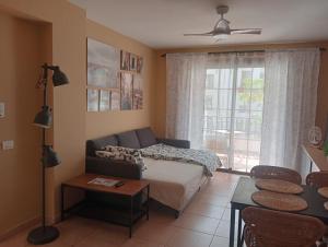 a living room with a couch and a window at Greatly located apartment with heated pool, Los Cristianos in Los Cristianos