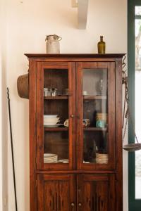 a wooden cabinet with plates and dishes in it at Villetta con giardino nel centro storico in Procida