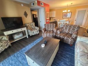 a living room with couches and a flat screen tv at The Beach is Only Steps Away (F2) BEACHFRONT - Sleeps 8 in Gulf Shores