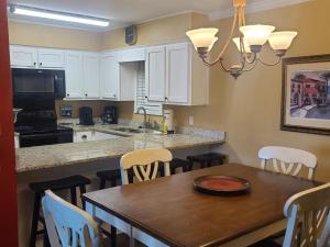 a kitchen with a wooden table and a dining room at The Beach is Only Steps Away (F2) BEACHFRONT - Sleeps 8 in Gulf Shores